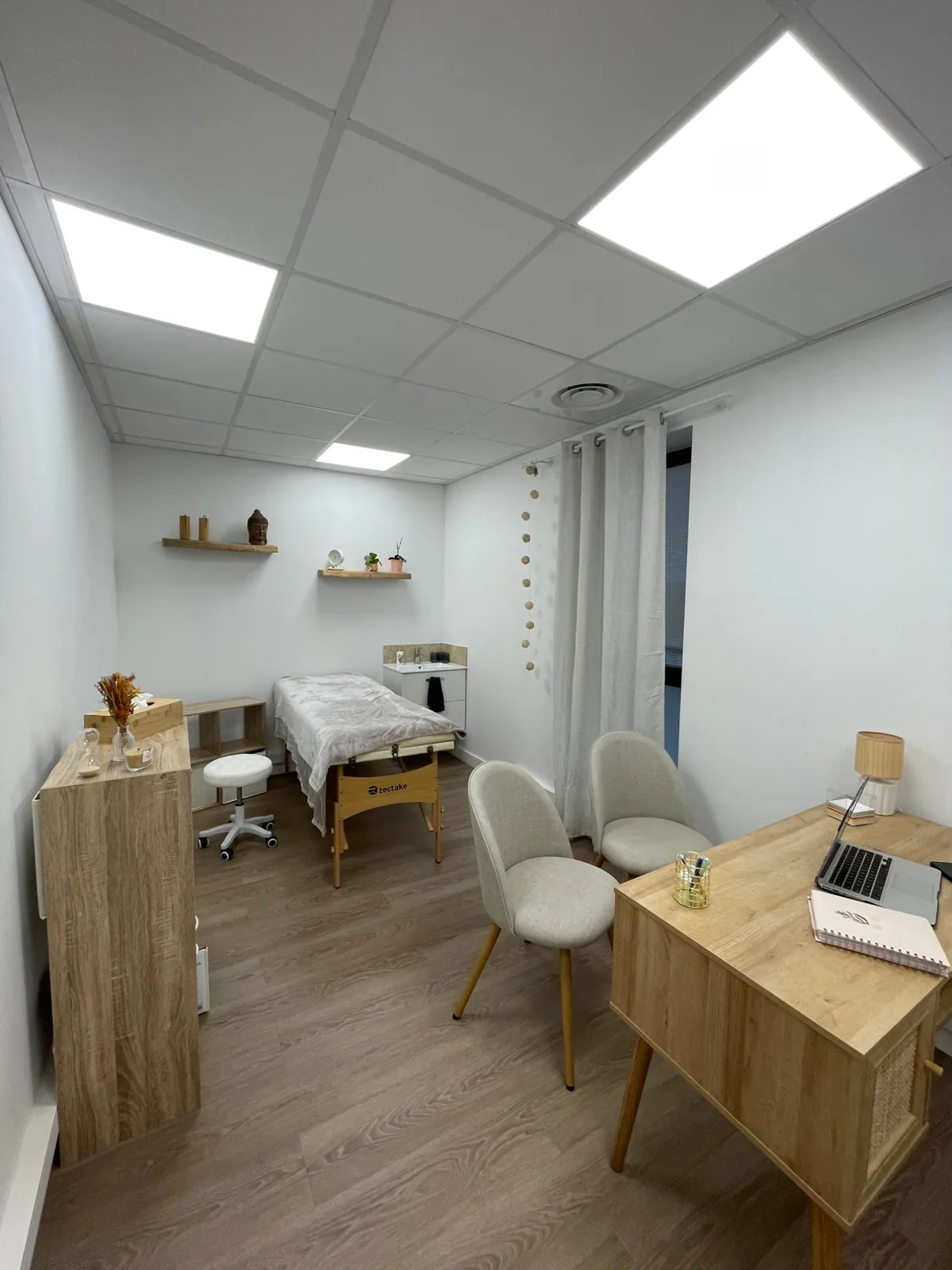 Le cabinet d'Élodie Dubos : table de soin, fauteuils et bureau en bois clair