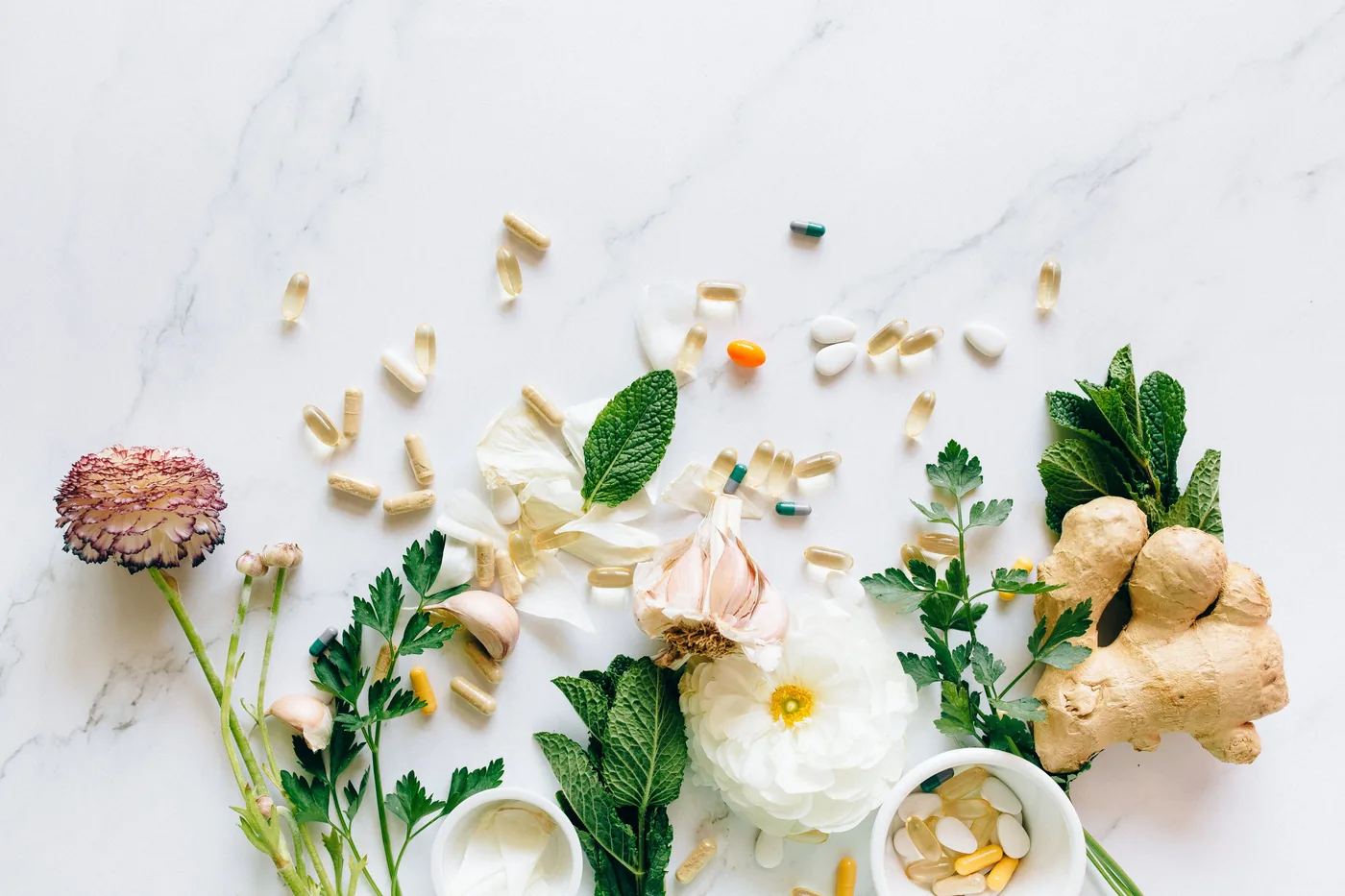 Fleurs séchées, plantes fraîches et compléments naturels disposés sur un plan en marbre
